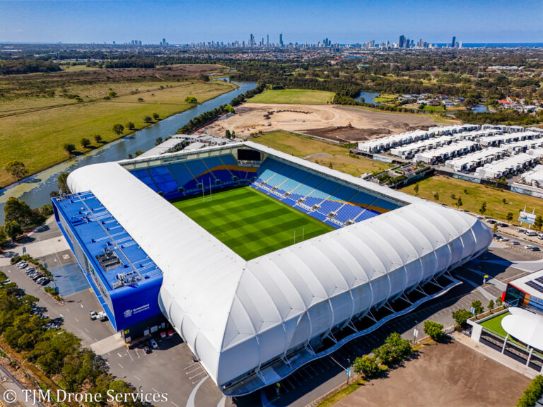 Aerial view of the city skyline beyond a football stadium on the Gold Coast, showcasing drone services for asset and infrastructure inspection