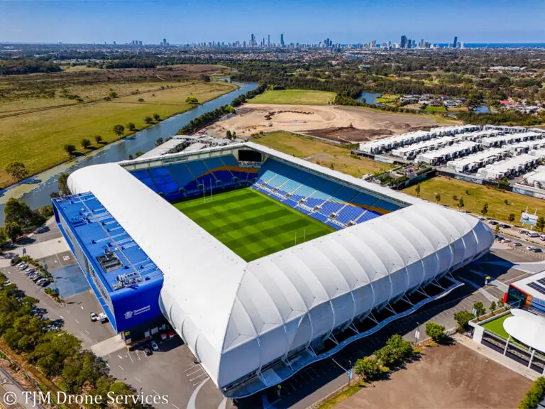 Aerial view of the city skyline beyond a football stadium on the Gold Coast, showcasing drone photography video for asset and infrastructure inspection